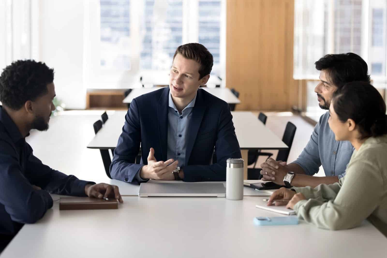 Business owner leading a small team meeting in a bright office
