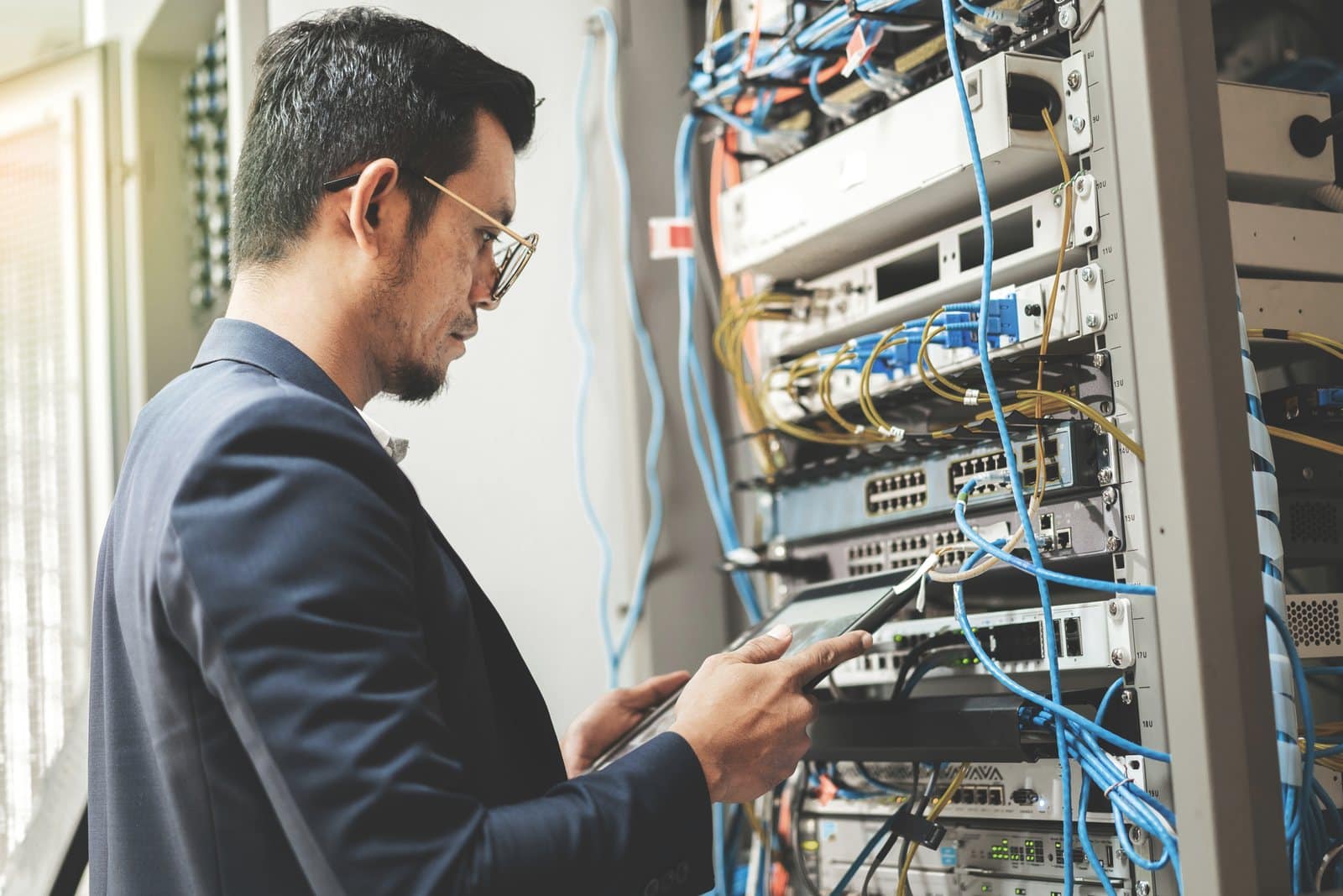 Technician checking network equipment in a server rack